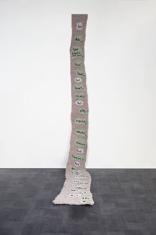 &Eacute;va Ostrowska, He is just playing hard to get I guess, tall knitted wool sculpture showing a cascade of unanswered text messages including babe, love, you ok, please, and I love you, contemporary textile art about digital desperation