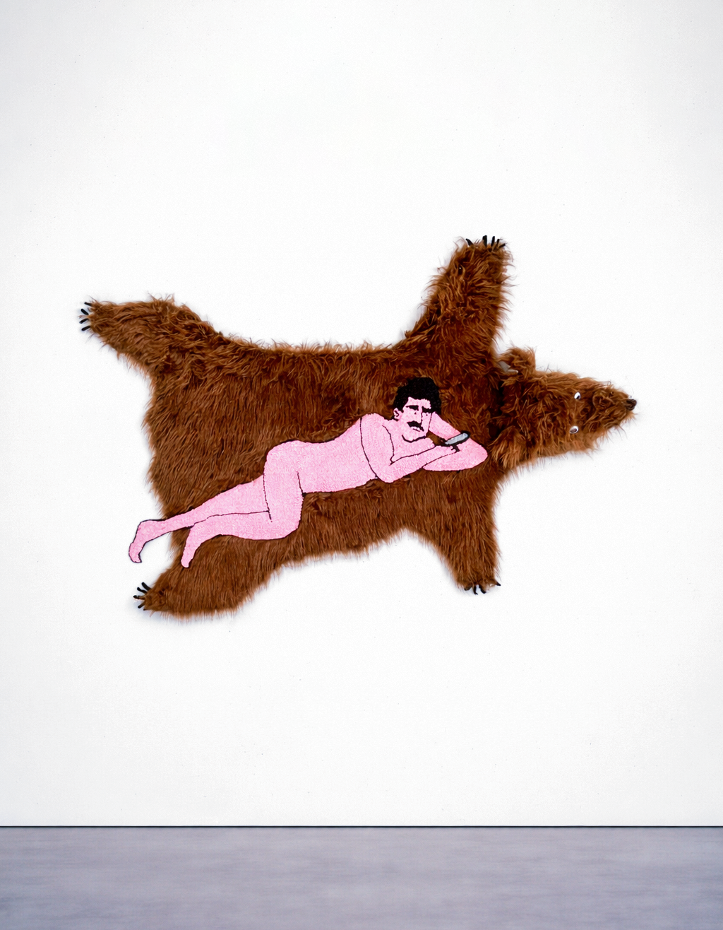 &Eacute;va Ostrowska, Last Night Eugene Spent the Evening Waiting for Her Text, tufted wool tapestry on bear-skin-shaped fake fur depicting a man scrolling his phone while lying down, contemporary textile art about digital distraction and modern intimacy