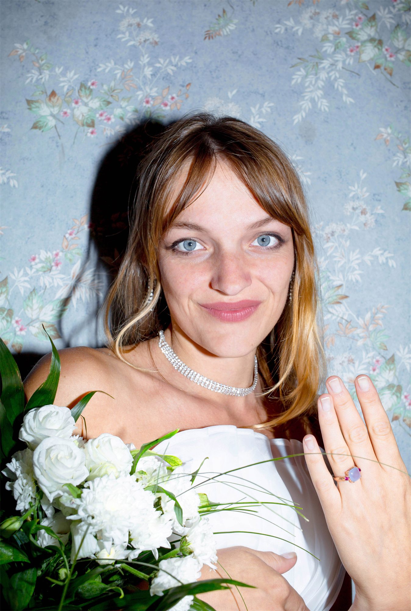 Éva Ostrowska showing the engagement ring she bought back for herself, white dress and bouquet, 2016