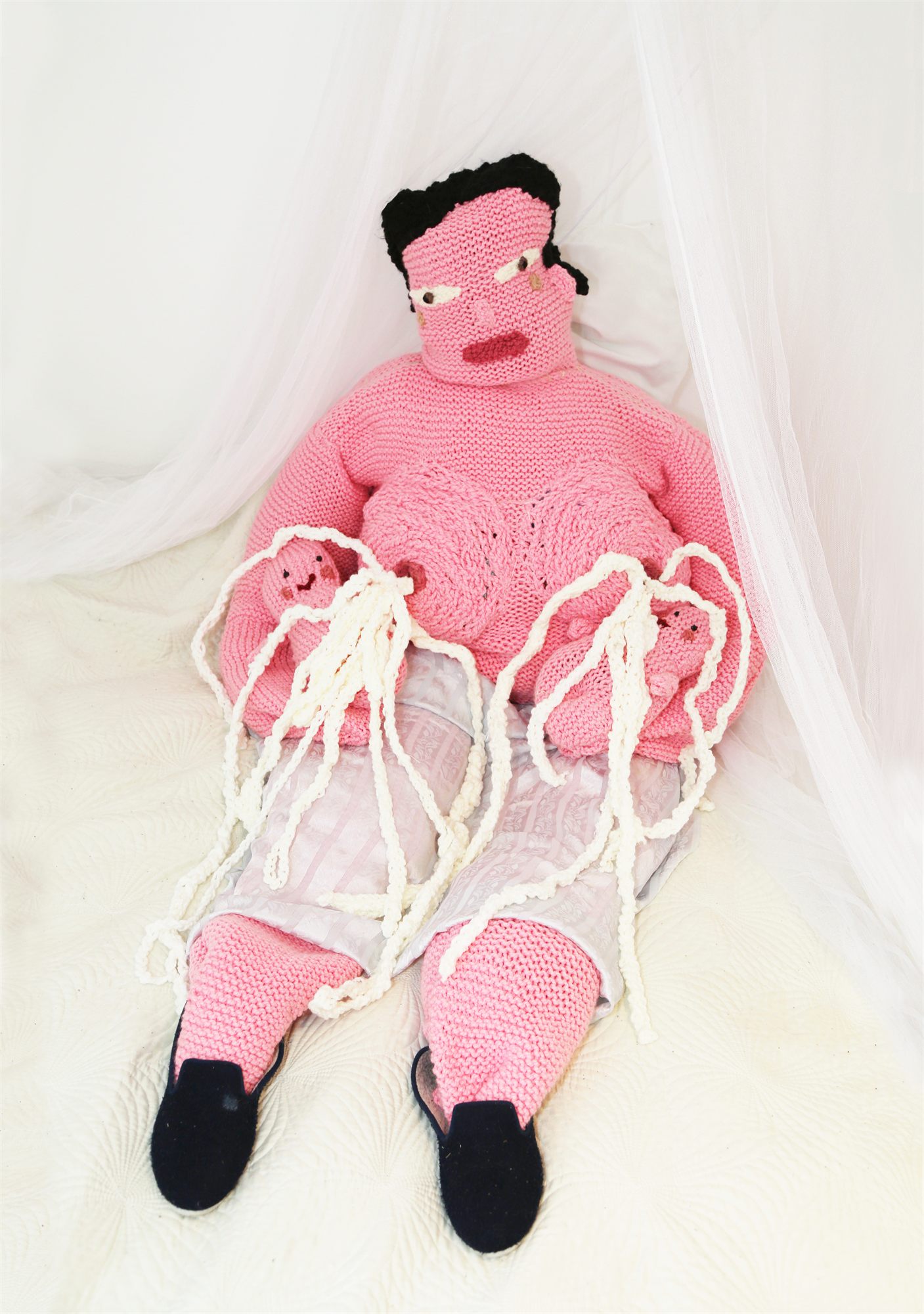 Éva Ostrowska, Too Much Love, pink knitted mother holding knitted babies under a white canopy, photographic performance